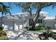Charming coastal home featuring a three car garage, lush landscaping, and a paver driveway at 5169 Sandy Shore Ave, Sarasota, FL 34242