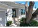 Front entrance featuring manicured landscaping, a beautiful mature tree and double front doors at 5169 Sandy Shore Ave, Sarasota, FL 34242