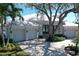 Charming home with a three-car garage, lush landscaping, and a grand oak tree in the front yard at 5169 Sandy Shore Ave, Sarasota, FL 34242