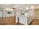 Open-concept kitchen and living area with island, stone accent wall and decorative lighting at 5169 Sandy Shore Ave, Sarasota, FL 34242