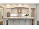 Kitchen island featuring marble counters, white cabinets and pendant lighting at 5169 Sandy Shore Ave, Sarasota, FL 34242
