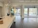 Bright, open-concept kitchen with island lighting, dark wood floors, and view to outdoor pool at 5169 Sandy Shore Ave, Sarasota, FL 34242