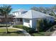 Beautifully landscaped backyard with a screened lanai, leading to waterfront views and lush greenery at 5169 Sandy Shore Ave, Sarasota, FL 34242