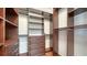 Custom walk-in closet featuring dark wood shelving, drawers, and hanging rods for optimal organization and storage at 5169 Sandy Shore Ave, Sarasota, FL 34242