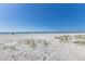 Scenic beach with white sand and dune grass, stretching to the horizon under a clear, sunny sky at 5400 Gulf Dr # 25, Holmes Beach, FL 34217