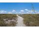 Inviting beach path with lush vegetation leading to the ocean at 5400 Gulf Dr # 25, Holmes Beach, FL 34217