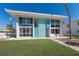 Stunning two-story condo with turquoise accents, large windows, and a lush green lawn at 5400 Gulf Dr # 25, Holmes Beach, FL 34217
