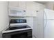 Kitchen with white cabinets, white appliances, and a black stovetop at 5400 Gulf Dr # 25, Holmes Beach, FL 34217