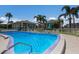 A community pool is surrounded by fenced patio and lush tropical landscaping near private residences at 5400 Gulf Dr # 25, Holmes Beach, FL 34217