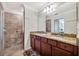 Bathroom showcasing double sinks with granite countertops and a glass door shower at 5527 Palmer Cir # 105, Bradenton, FL 34211
