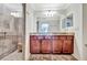 Bathroom featuring a large mirror, wood cabinets, and glass door shower at 5527 Palmer Cir # 105, Bradenton, FL 34211