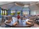 Elegant dining room featuring tables set with glassware, napkins, and a centerpiece, surrounded by large windows and blue curtains at 5527 Palmer Cir # 105, Bradenton, FL 34211