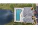 Aerial view of a swimming pool with lounge chairs, surrounded by lush landscaping and adjacent parking at 5743 Sabal Trace Dr # 101B57, North Port, FL 34287