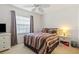 Cozy bedroom features striped bedding and a ceiling fan at 5743 Sabal Trace Dr # 101B57, North Port, FL 34287
