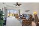 Living room with comfortable seating, tray ceiling, large windows, and serene water view at 5743 Sabal Trace Dr # 101B57, North Port, FL 34287
