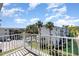Balcony view overlooking landscaped grounds, palm trees, and nearby condo buildings with parking at 5922 Garden Ln # A31, Bradenton, FL 34207
