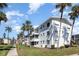 Well-maintained condo building with manicured lawn and tropical palm trees under a bright blue sky at 5922 Garden Ln # A31, Bradenton, FL 34207