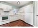 Charming kitchen with white cabinets, appliances, and hardwood floors offering a cozy and functional space at 5922 Garden Ln # A31, Bradenton, FL 34207