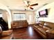 Spacious living room featuring hardwood floors, comfortable leather couches, and a bright window view at 6243 Mayberry Ave, North Port, FL 34287