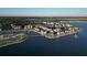 Aerial view of lakeside apartments and stores, surrounded by lush green trees and a blue lake at 6547 Oakland Hills Dr, Lakewood Ranch, FL 34202