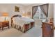 Comfortable bedroom featuring a decorative wood bed frame, neutral walls, and a view of the outdoors at 6547 Oakland Hills Dr, Lakewood Ranch, FL 34202