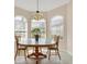 Inviting breakfast nook featuring a round table with three chairs, decorative chandelier and three windows with lots of sunlight at 6547 Oakland Hills Dr, Lakewood Ranch, FL 34202