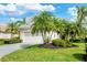 Beautiful house with a manicured lawn, mature palm trees, and a large driveway at 6547 Oakland Hills Dr, Lakewood Ranch, FL 34202