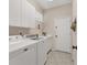 Bright laundry room with white cabinets and modern appliances at 6547 Oakland Hills Dr, Lakewood Ranch, FL 34202