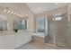 Elegant main bathroom with dual vanities, a soaking tub enclosed by glass blocks, and a separate glass-enclosed shower at 6547 Oakland Hills Dr, Lakewood Ranch, FL 34202