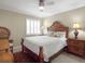 Comfortable bedroom with a wooden bed frame, decorative lamps, and a cozy chair at 6700 Gulf Dr # B8, Holmes Beach, FL 34217