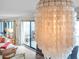 Living area featuring a unique chandelier with white shell elements and a glimpse of the ocean at 6700 Gulf Dr # B8, Holmes Beach, FL 34217