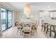 Bright dining room featuring stylish chandelier, seating for six, and sliding glass doors to the balcony at 6700 Gulf Dr # B8, Holmes Beach, FL 34217