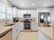 Modern kitchen featuring stainless steel appliances, bright white cabinets, and granite countertops at 6700 Gulf Dr # B8, Holmes Beach, FL 34217