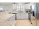 Well-lit kitchen with stainless steel appliances, bright white cabinets, and granite countertops at 6700 Gulf Dr # B8, Holmes Beach, FL 34217
