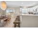 Bright kitchen with white cabinets, granite counters, bar seating, dining table, and beach-themed decor at 6700 Gulf Dr # B8, Holmes Beach, FL 34217