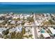 Aerial view showcases a white home near the ocean and in a charming coastal community at 701 N Bay Blvd, Anna Maria, FL 34216