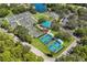 An aerial view of the tennis and pickleball courts, a community green space, and a beautiful lake at 7017 Lennox Pl, University Park, FL 34201