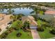 Expansive home with manicured lawn, lush landscaping, and serene lake views at 7017 Lennox Pl, University Park, FL 34201