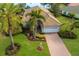 Expansive home with manicured lawn, lush landscaping, and mature palm trees at 7017 Lennox Pl, University Park, FL 34201