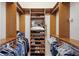 Spacious walk-in closet with built-in wooden shelving and rods for organized storage and display at 7017 Lennox Pl, University Park, FL 34201