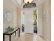 Inviting entryway with tile flooring, transom window, and views of the beautifully landscaped yard at 7017 Lennox Pl, University Park, FL 34201