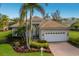 Beautiful single Gathering home featuring a tile roof, mature palm trees, and a well-manicured lawn at 7017 Lennox Pl, University Park, FL 34201