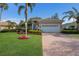 Beautiful home featuring a tile roof, mature palm trees, and a well-manicured lawn at 7017 Lennox Pl, University Park, FL 34201