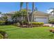 Beautiful home featuring a tile roof, mature palm trees, and a well-manicured lawn at 7017 Lennox Pl, University Park, FL 34201
