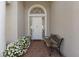 Charming front porch featuring red brick, potted white flowers, and a lovely bench at 7017 Lennox Pl, University Park, FL 34201