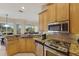 A lovely kitchen with stainless appliances, wood cabinets, and granite countertops at 7017 Lennox Pl, University Park, FL 34201