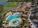 Aerial view of resort-style pool, clubhouse, and golf course, featuring lush landscaping and amenities at 8403 Grand Estuary Trl # 103, Bradenton, FL 34212
