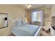 Comfortable bedroom with white furniture, light blue bedding, bright windows and a serene ambiance at 8403 Grand Estuary Trl # 103, Bradenton, FL 34212