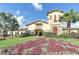Elegant clubhouse featuring manicured lawns, vibrant flowerbeds, and a charming architectural design at 8403 Grand Estuary Trl # 103, Bradenton, FL 34212