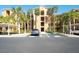A multi-story condo building with palm trees and designated accessible parking at 8403 Grand Estuary Trl # 103, Bradenton, FL 34212